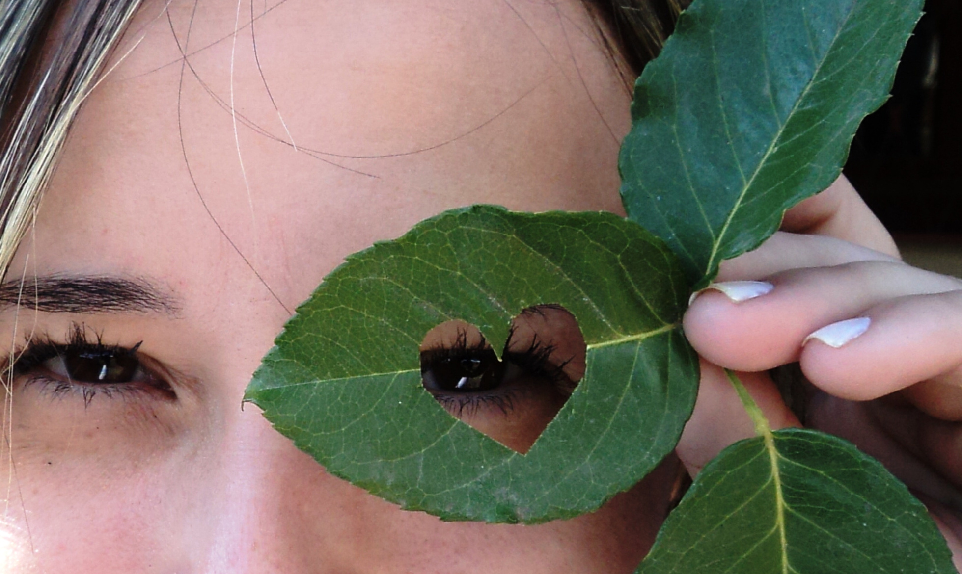 Woman Looking Through a Leaf